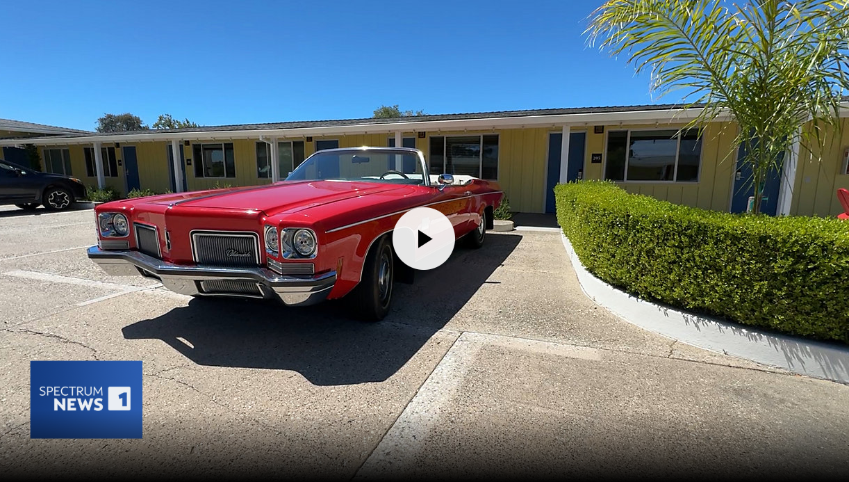 An image of a red car in front of the Foothills Motel in Auburn with the Spectrum News logo
